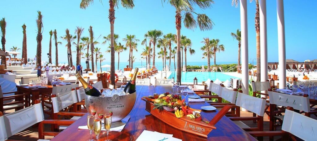 Outdoor restaurant with palm trees and pool in Marbella