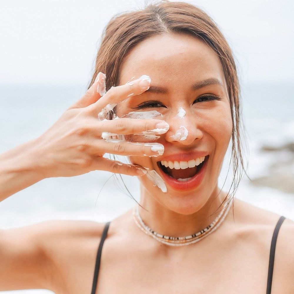 woman putting on sunscreen