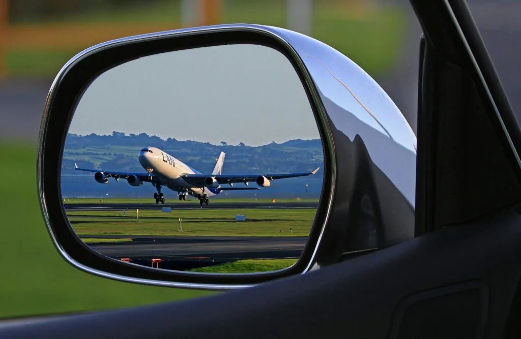 Car rearview mirror with a plane reflected in it